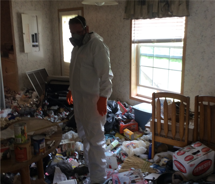 A SERVPRO employee in full personal protective equipment inside a hoarding home in Hamlin, Pa