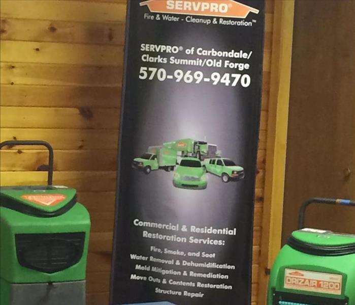 A picture of the SERVPRO logo/banner with some of our equipment in our Lackawanna County facility.
